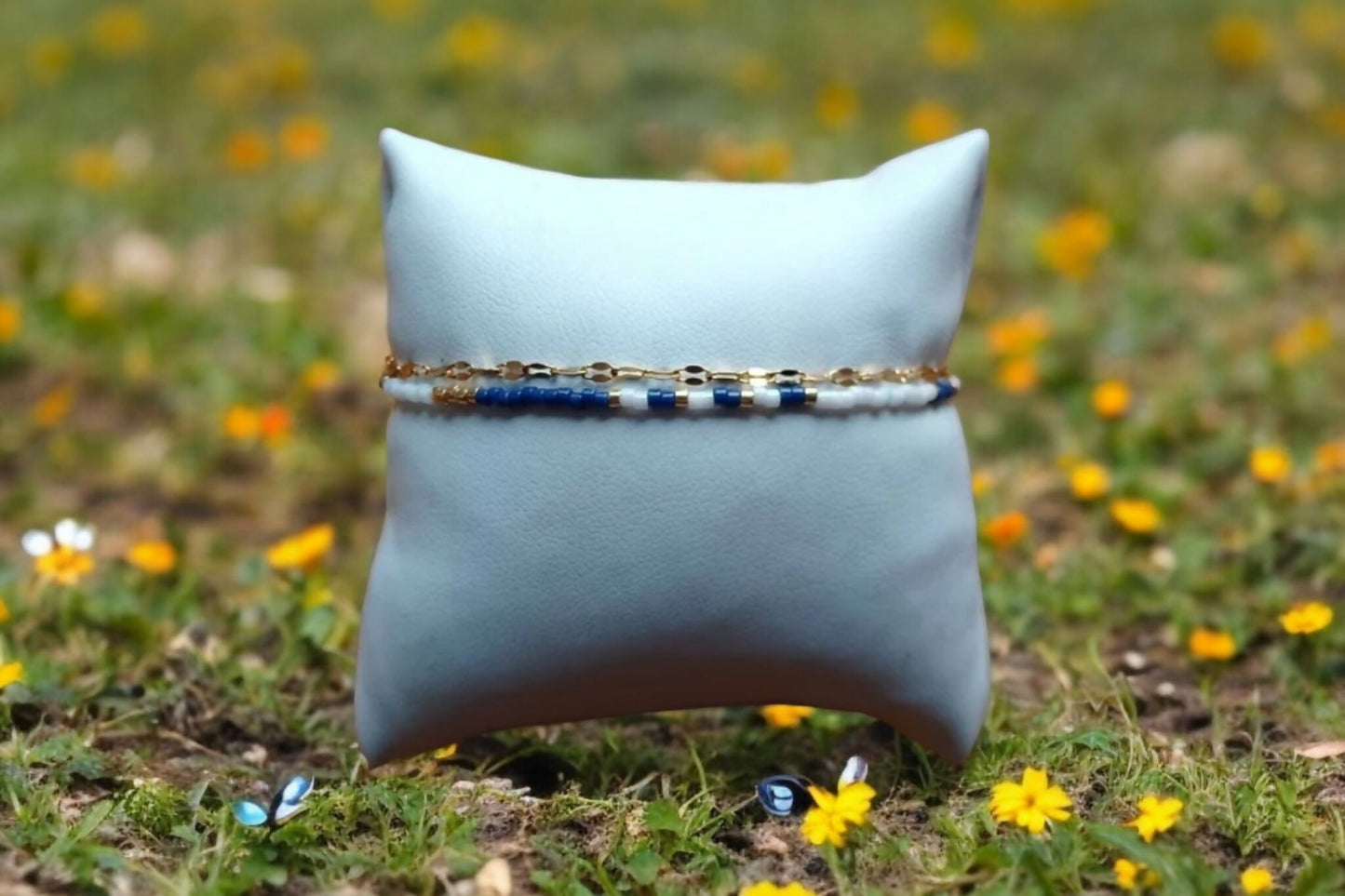 Bracelet de perles bleu marine et blanc et chaîne dorée.