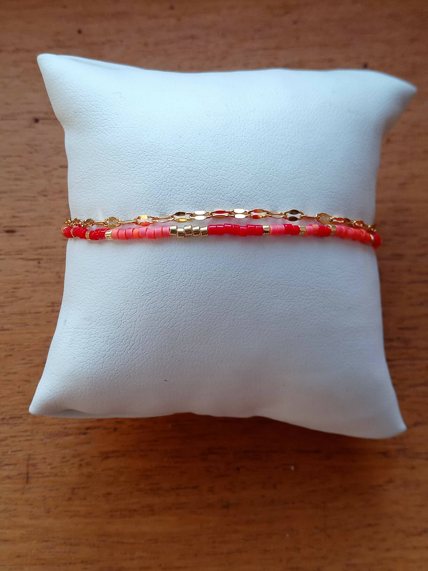 Bracelet de perles rouge et corail et chaîne dorée.