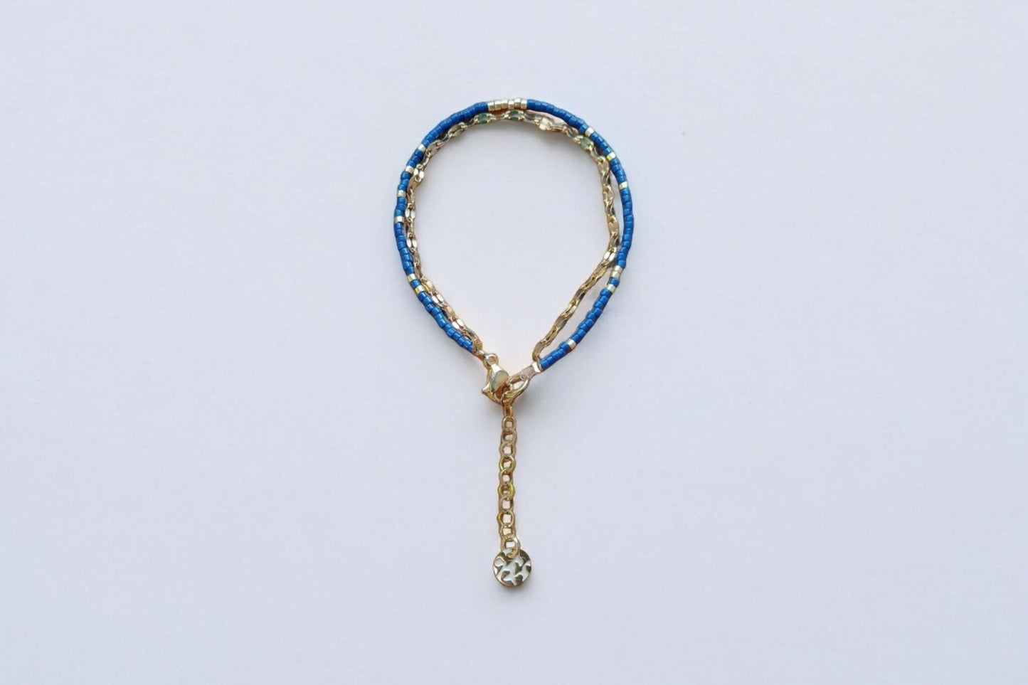 Bracelet de perles bleu marine et chaîne dorée.