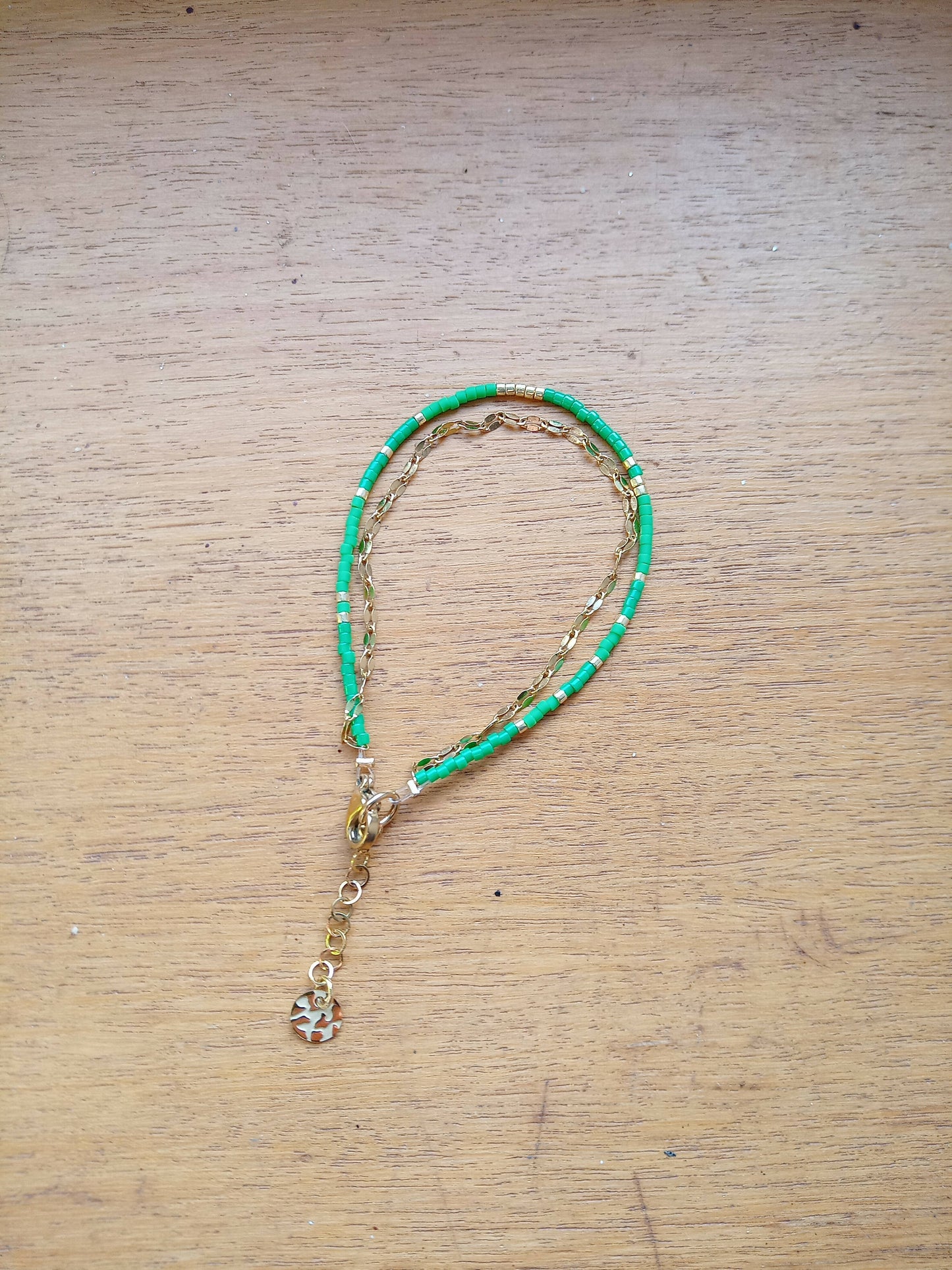 Bracelet de perles deux verts et chaîne dorée.